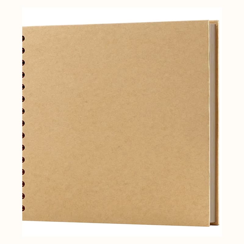 Album de scrapbooking carré à couverture kraft et reliure à spirale, posé à plat sur fond clair.