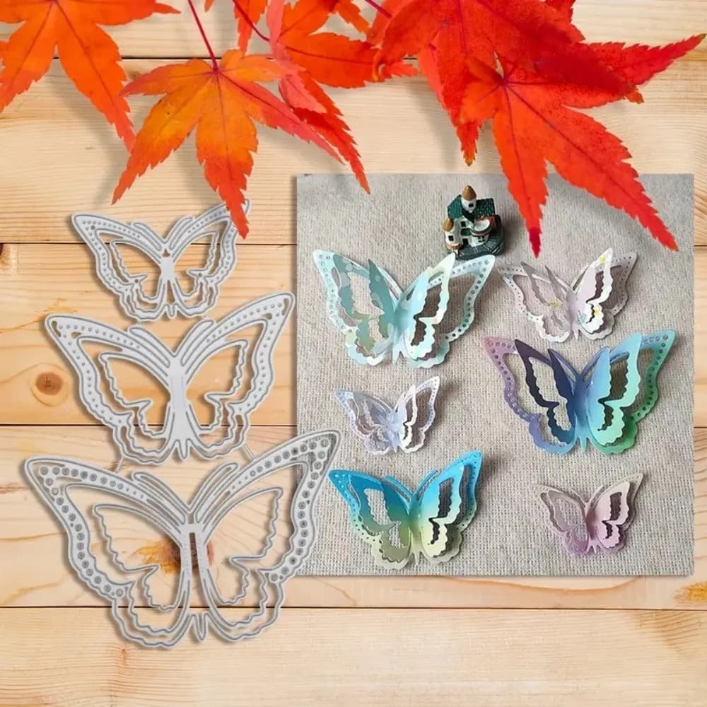 Trois matrices de papillons de tailles différentes sur un plan de bois clair, à côté de six papillons découpés en dégradés de bleu, vert et parme sur un carré de toile grise.