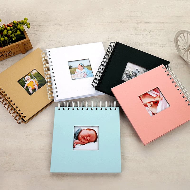 Cinq mini albums à spirale de couleurs différentes, chacun avec une photo visible dans la fenêtre de couverture.